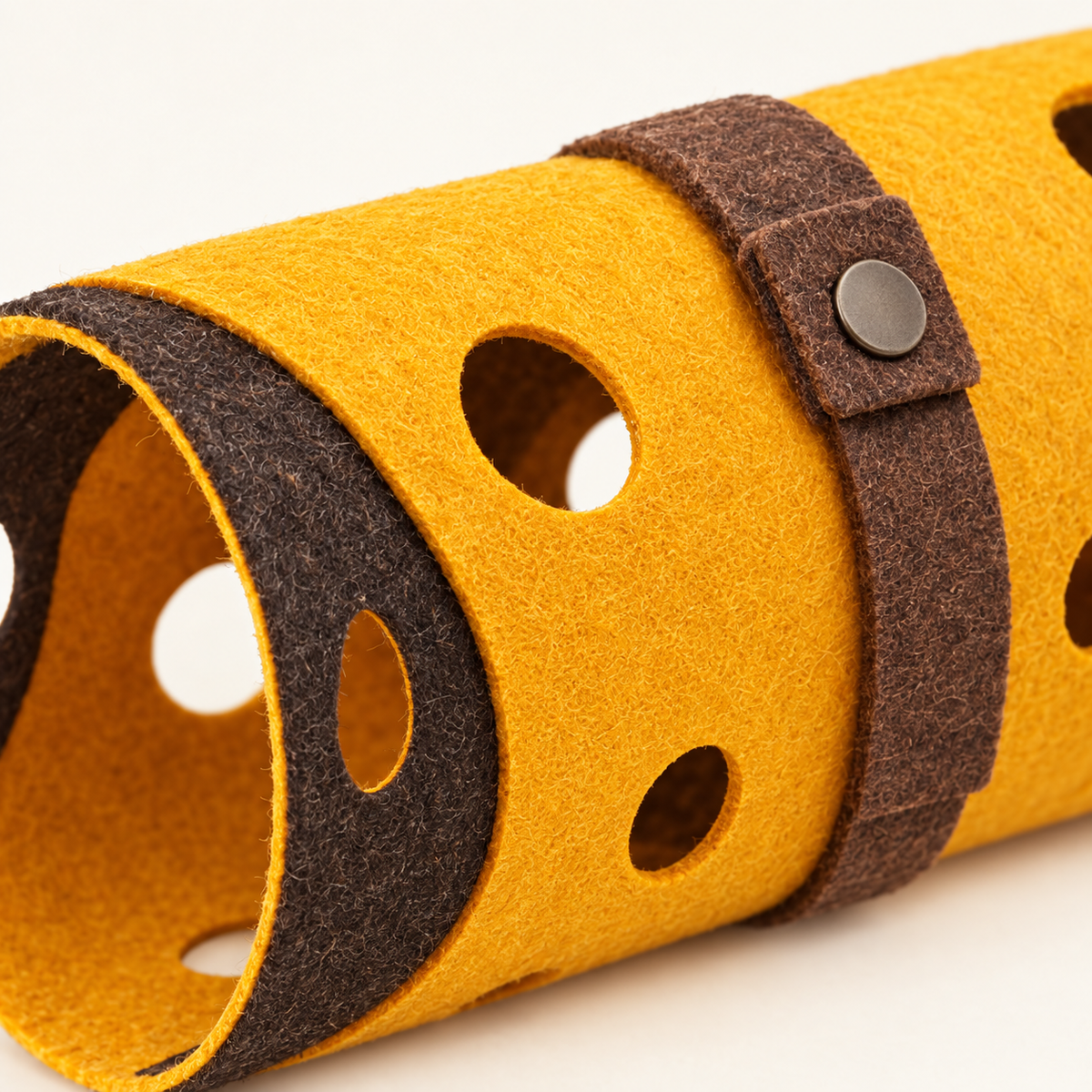 Close detail of the thickness of the pressed felt edge and the brown felt strap with its press stud fastening