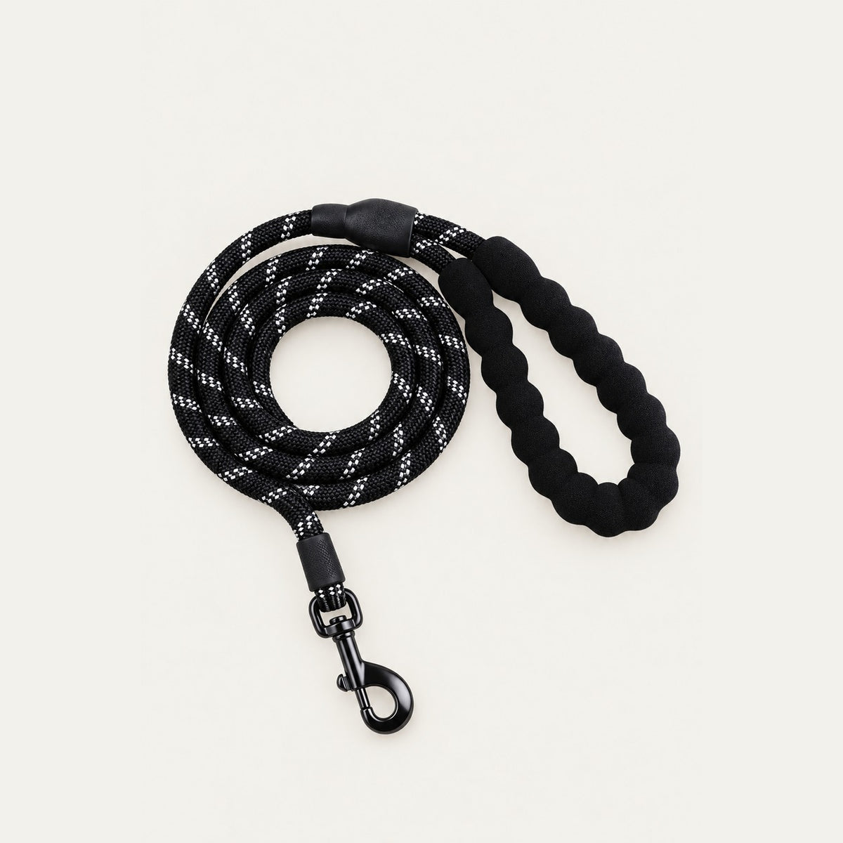 Coiled black rope dog leash with white reflective threads, black padded braided handle loop and dark metal swivel snap hook