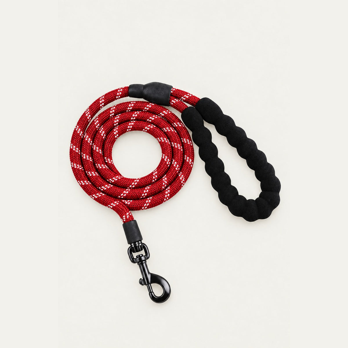 Coiled deep red rope dog leash with white reflective threads, black padded braided handle loop and dark metal swivel snap hook
