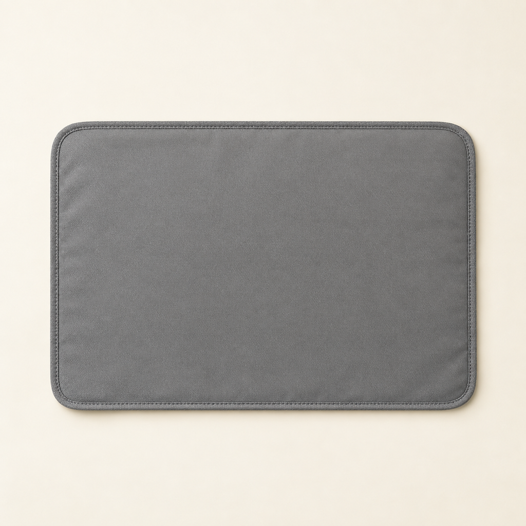 A flat grey waterproof cat litter mat photographed from directly above, lying flat and empty on a warm cream background.
