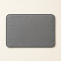 A flat grey waterproof cat litter mat photographed from directly above, lying flat and empty on a warm cream background.