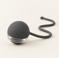 Dark grey ribbed silicone self-rolling cat toy ball on a clear plastic band, with a braided cord tail trailing behind