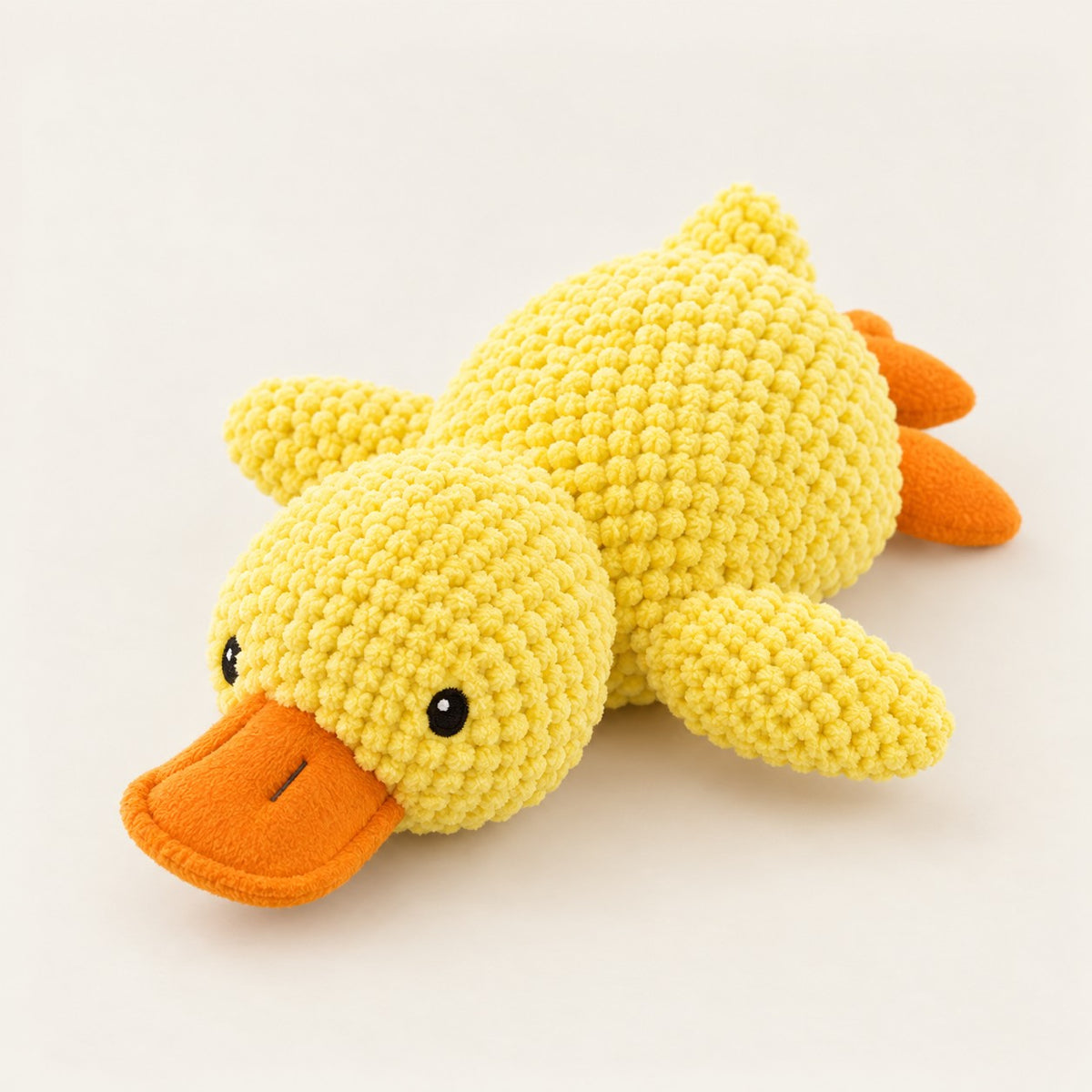 Yellow plush duck squeaky dog toy with raised bobble knit texture and flat orange bill and feet