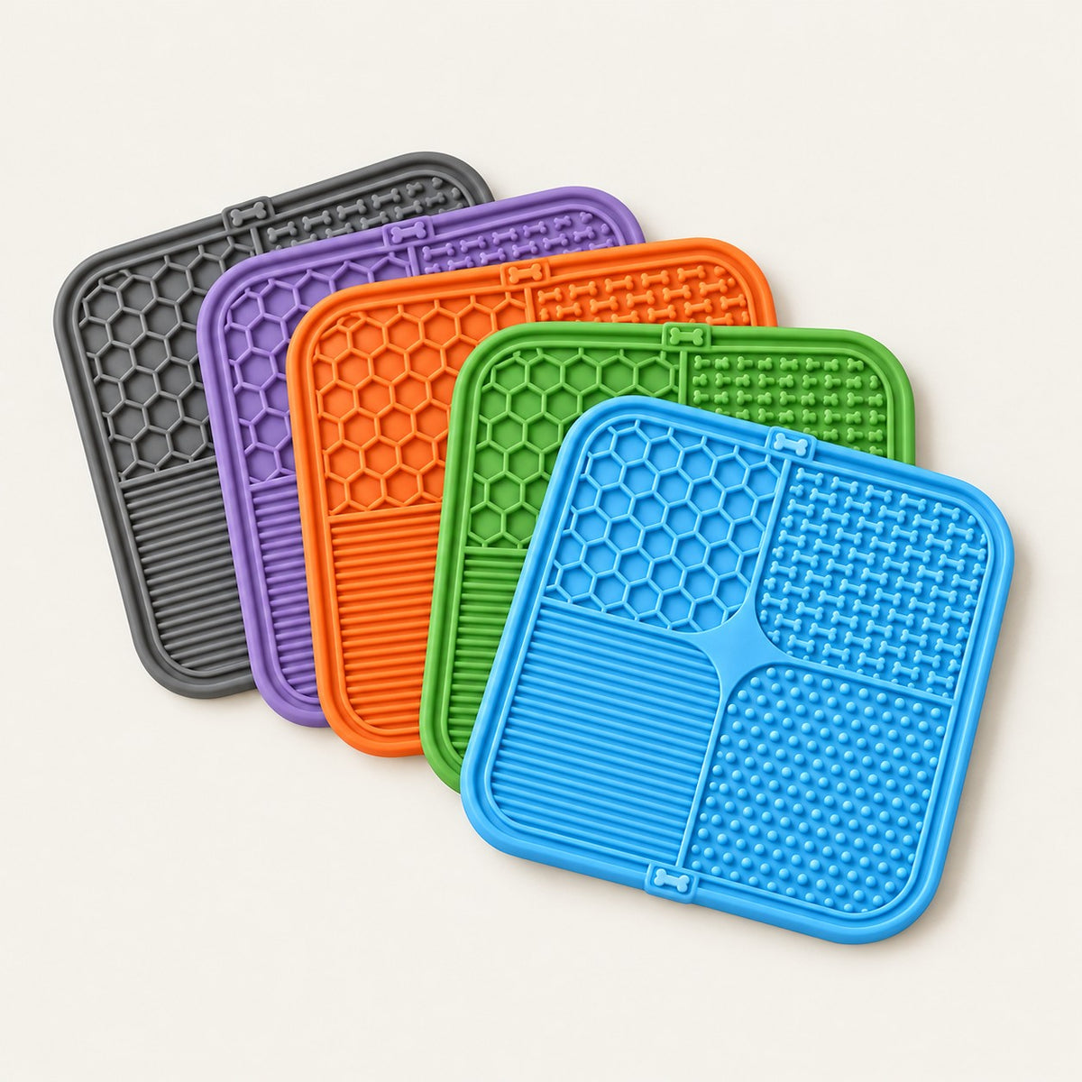 Five silicone lick mats fanned out in blue, green, orange, purple and grey